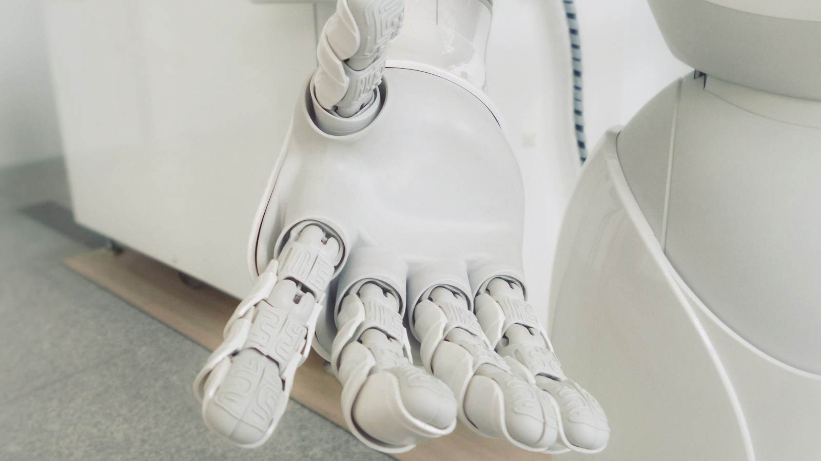 Side-by-side technology comparison on desk displays: a rigid decision tree flowchart on one screen contrasted with an intelligent, natural conversational AI assistant interface on the other.