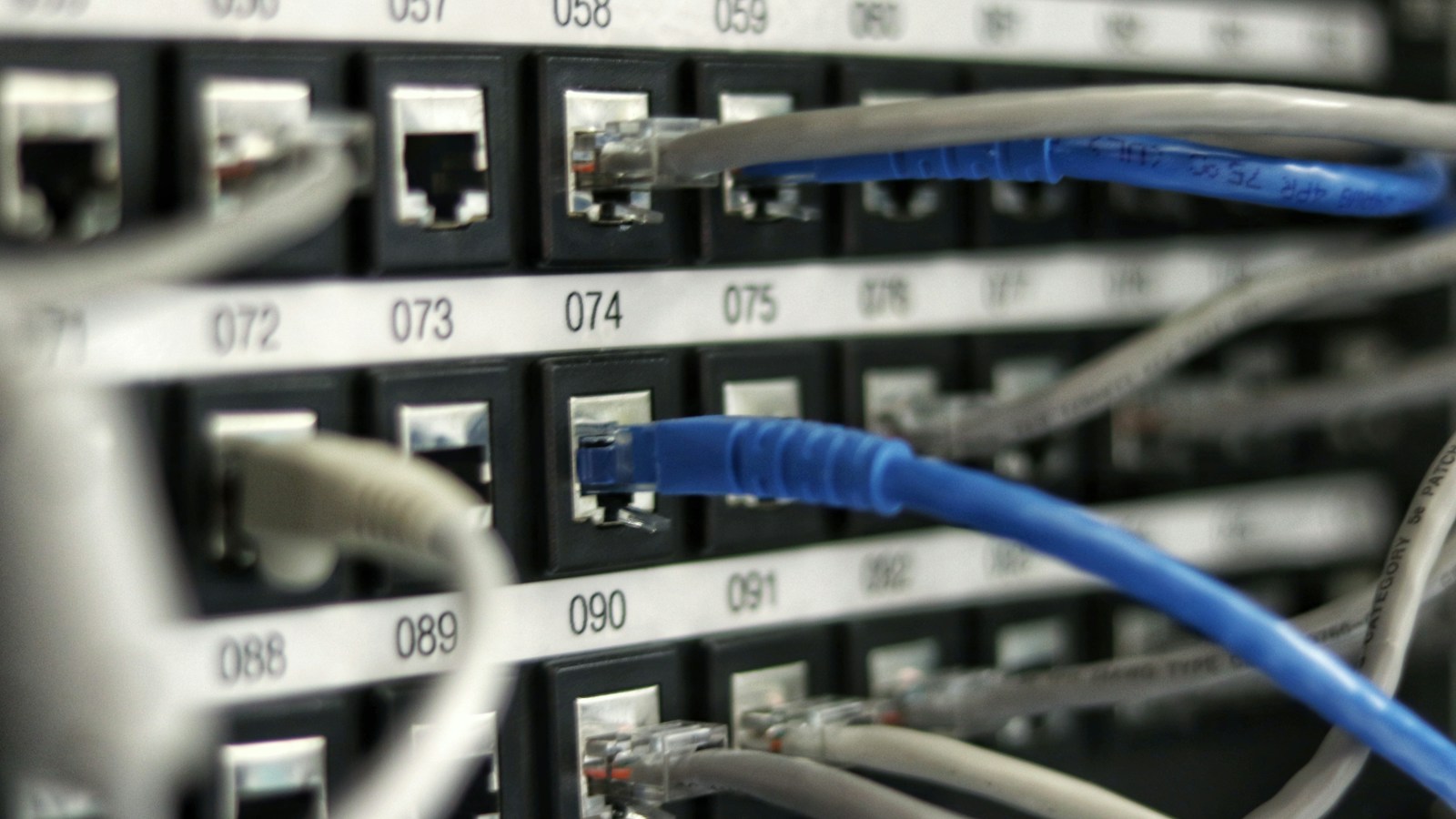 IT systems administration desk demonstrating the 3-2-1 backup strategy with a ruggedized external SSD drive, dual-bay network NAS storage array, and cloud backup sync logs.