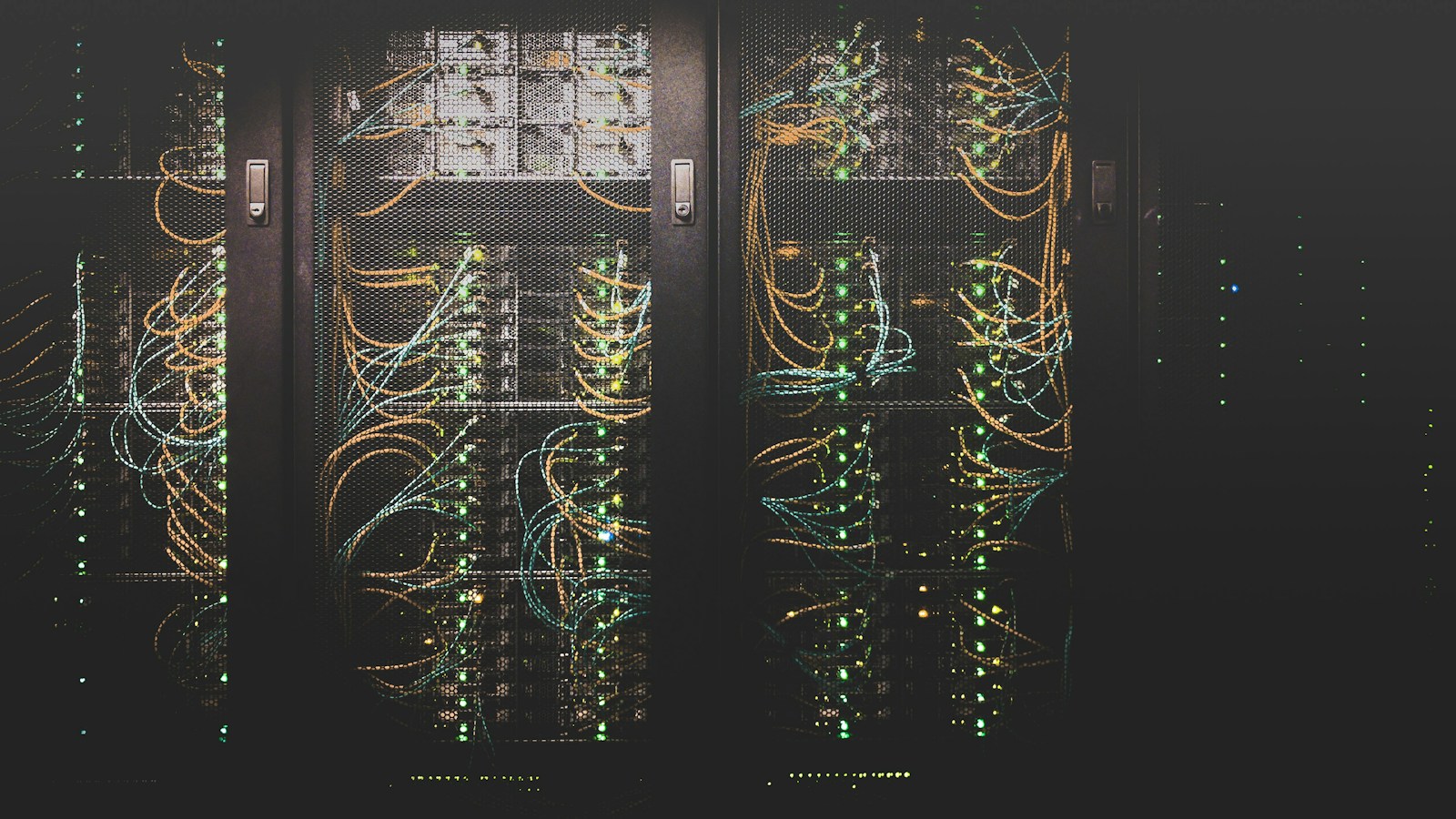 Modern cloud data center server racks glowing with cool blue LED lighting, with an engineer laptop displaying virtual private server (VPS) and cloud cluster architecture metrics.