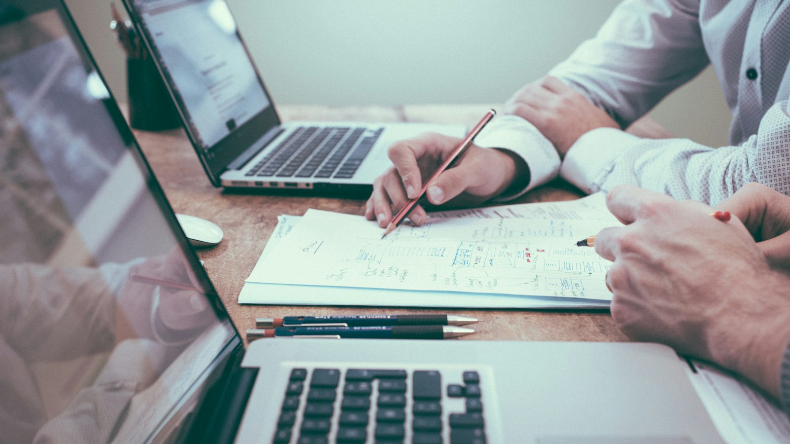 Business process automation planning workspace with an ultra-wide monitor displaying an automated workflow connecting CRM leads, instant invoice generation, and customer alerts.