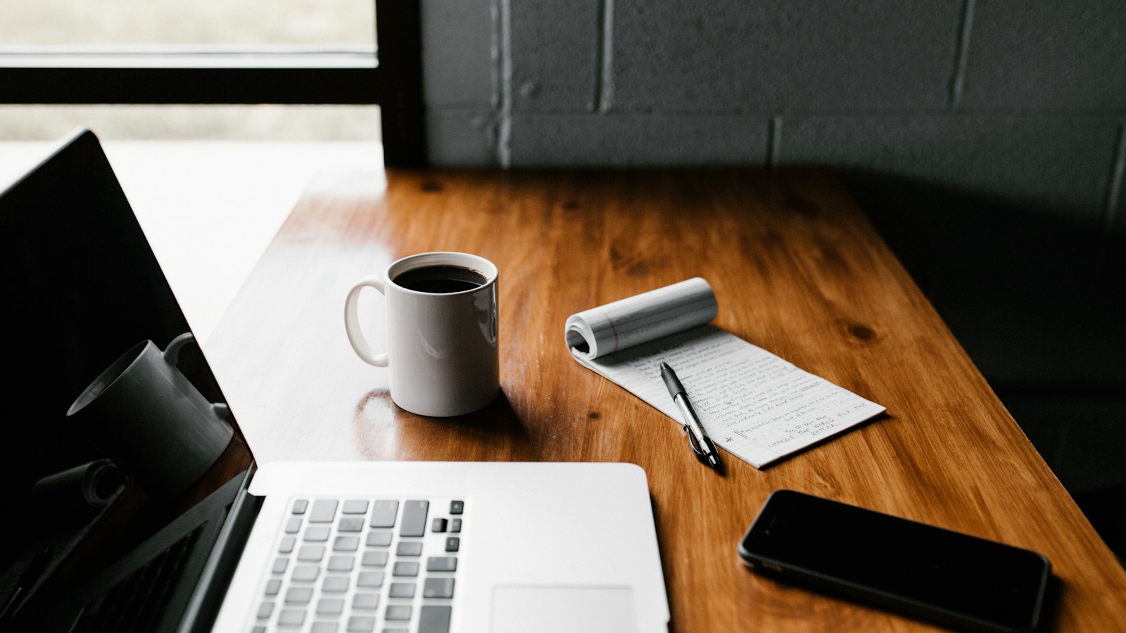 Editorial content strategist writing on a laptop with an article editor showing SEO readability score, keyword density meter, structured headings, and an outline notepad.